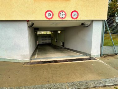 Cenevre, İsviçre - 15 Eylül 2021: Eğimli ve işaretli bir binanın altında özel bir yeraltı otoparkının girişi