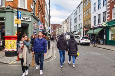 Londra, Birleşik Krallık - 6 Mart 2022: SOHO mahallesinde kaldırımda birçok modern insan ile cadde meşgul
