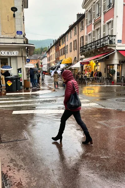 Annecy, Fransa - Ekim 05 2021: Fransız kasabasının ıslak kaldırımında tarihi yapılarla birlikte bir kişi yürüyor