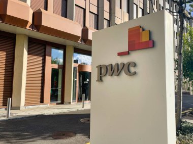 Cenevre, İsviçre - 08 Eylül 2022: PWC sigorta ve vergi şirketinin ofis binasının önündeki üzerinde logo yazan tabela