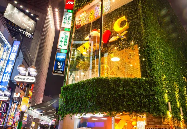 東京都 2012年11月26日 夜の活気ある渋谷のショップウィンドウ ビルの反対側に広告看板がある歩行者天国で — ストック写真