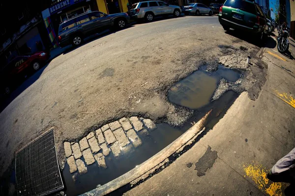 2012年4月21日 美国纽约 布鲁克林的街道并不都是完好无损的 因为我们在这里看到了一层沥青和下面的旧砖块 就像在打孔一样 — 图库照片