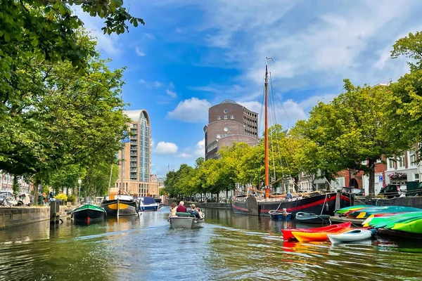 stock image The Hague, Netherlands - June 19 2022: elegant boat in a typical canal with a vibrant blue sky, canoes and classic boat