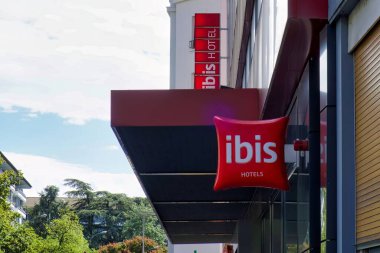 Cenevre, İsviçre - 08 Eylül 2022: Ibis otelinin logosu bir şehrin dışında asılı.