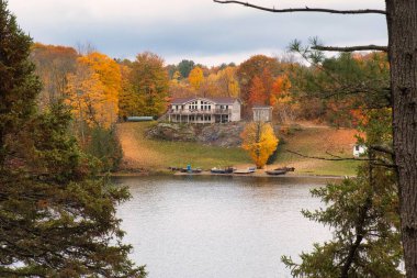 kawartha lakes, canada - 20 October 2022: a cabin on the shore of a small lake in the kawartha lakes region in fall colors