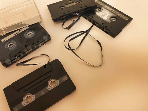 different cassette tapes with broken tape laying around ready to rewound