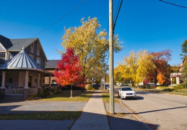 gananoque, canada - 22 October 2022 : residential neighborhood street with historic houses and trees in fall colors
