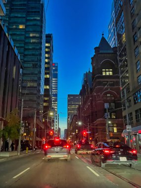 Toronto, Canada - 24 October 2022: view of skyscrapers at night with busy street with cars driving and breaking