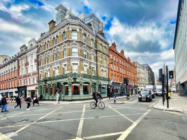 Londra, Birleşik Krallık - 07 Mart 2022: bisikletçi yolda gidiyor ve asfaltta haçlarla dolu bir kavşağı geçiyor