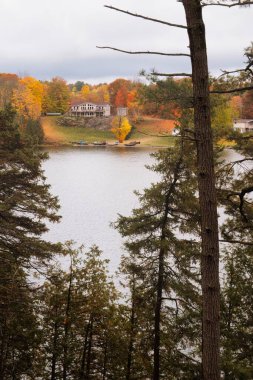 kawartha lakes, canada - 20 October 2022: a cabin on the shore of a small lake in the kawartha lakes region in fall colors