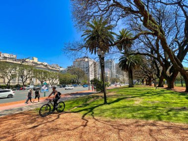 buenos aires, Argentina - 27 October 2022: cyclist in small park in the city with palm trees
