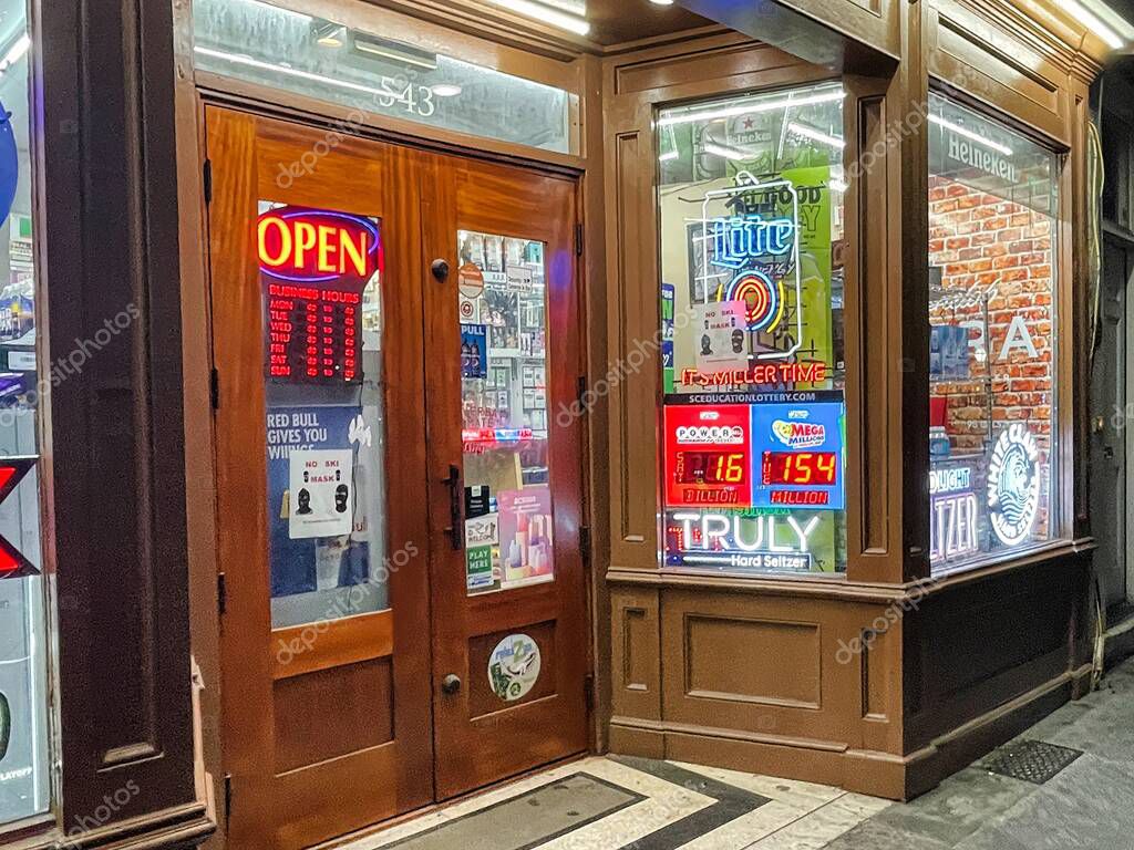 Charleston, united states - november 5 2022: the entrance of a liquor store downtown a university town with alcohol advertisements all over the window