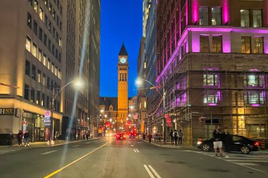 Toronto, Kanada - 24 Ekim 2022: Belediye binası kulesinin olduğu gece sokakta arabalar