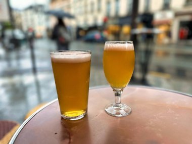 Paris, Fransa - 11 Nisan 2023: Saint Germain des Pres 'deki romantik restoran terasında sandalyeler ve masa bira bardakları ve Paris bulvarı