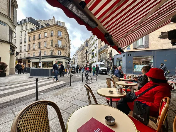 2023年4月11日 法国巴黎 一位妇女坐在圣日耳曼区巴黎街道人行道上的酒吧或餐馆旁边 — 图库照片