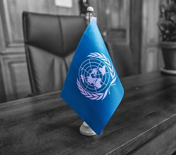 12月15日 蓝色的联合国旗帜矗立在一个办公室的桌子上 — 图库照片