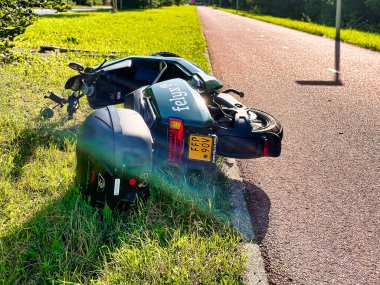 Lahey, Hollanda - 09 Ağustos 2021: bisiklet yolu boyunca terk edilmiş ve kırılmış bir kiralık scooter