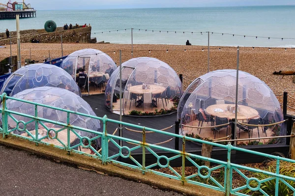 stock image Brighton, United Kingdom - March 04 2022: igloos or pods have been placed on a restaurant terrace near the pier of the english seaside resort for private dining experience