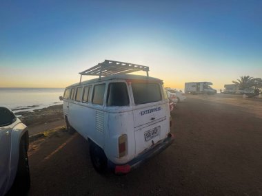 colonia del sacramento, uruguay - Kasım 2 2022: Deniz veya okyanus batımı manzaralı bir Volkswagen minibüsü veya otobüs