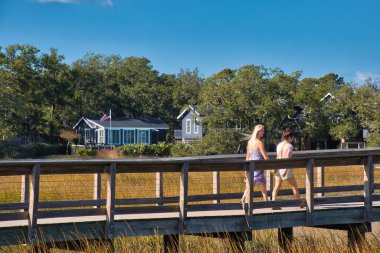 Charleston, Birleşik Devletler - Kasım 7 2022: bir nehir ve bir yerleşim yeri veya mülk uzun bir sahil yolu bataklığı ve insanlar