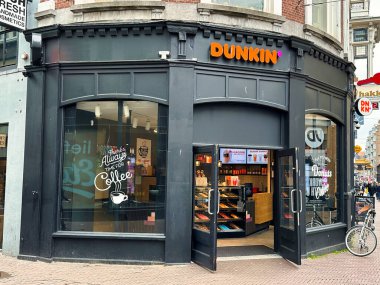 Hague, Hollanda - 21 Mart 2022: Dunkin Donut fast food zincirinin önü ve işaretleri
