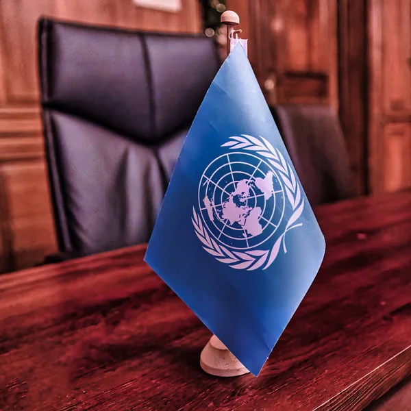 12月15日 蓝色的联合国旗帜矗立在一个办公室的桌子上 — 图库照片