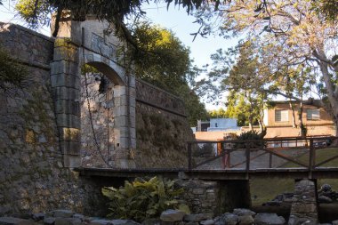 Colonia del sacramento, uruguay - 2 Kasım 2022: UNESCO dünya mirası kolonisinin Barrio tarihindeki San Miguel Kalesi 'nin asma köprüsündeki insanlar