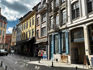 Lille, Fransa - 12 Nisan 2023: Lille, Fransa - 12 Nisan 2023: Bir adam tarihi eski kasabadaki bir alışveriş caddesinin kaldırımında dükkan vitrinleriyle yürüyor.