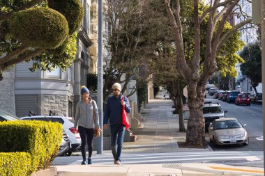 San Francisco, ABD - 14 Şubat 2020: Tipik bir San Francisco caddesinin kaldırımında yürüyen ve sohbet eden iki kişi