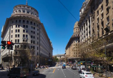 Buenos Aires, Arjantin - 04 Kasım 2022: Arabalar şehir merkezindeki bir caddede insanlar ve etrafındaki tarihi binalarla birlikte sürüyorlar.
