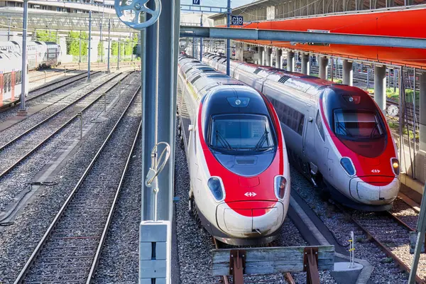 stock image geneva, switzerland - 08 September 2022: swiss modern trains in red and white are parked near a rail station on a shunting terrain