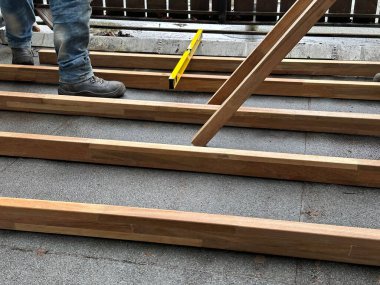 Lahey, Hollanda - 10 Mayıs 2023: güverte bir çatıdaki eski ahşap teras güvertesini yenisiyle değiştirmekle meşgul.