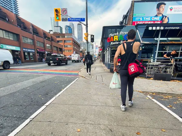 stock image toronto, canada - 25 October 2022: person in sports gear on the sidewalk of gay church street with bars restaurants shops and gay or lgbtq clubs