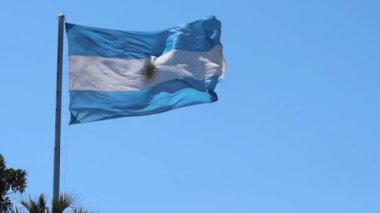 Arjantin 'in ulusal mavi beyaz bayrağı. Mavi gökyüzünde sarı bir direğin üstünde.