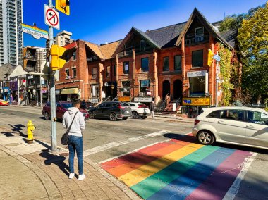 toronto, canada - 24 October 2022: person at pedestrian crossing painted in rainbow colors on gay church street