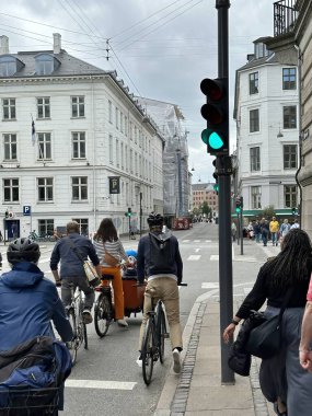 Kopenhag, Danimarka - 24 Temmuz 2023: turistler ve bisikletçiler şehir merkezindeki tarihi binaların önünden geçiyor