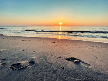 Den Haag, Hollanda - 16 Haziran 2021: İnsanlar güneşin ve plajın tadını çıkarıyor ve günbatımına hayran.