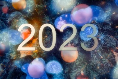 blurry bokey christmas lights during holiday season and 2023 sign