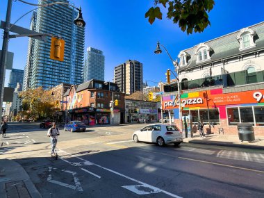 Toronto, Kanada - 24 Ekim 2022: Gay kilise sokağında scooter kullanan ve bar restoranları ve gay veya lgbtq kulüpleri olan bir kişi