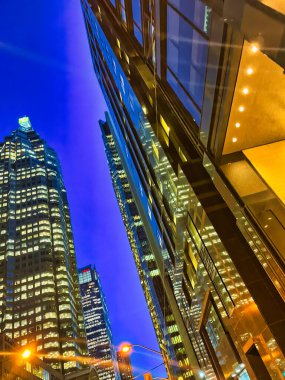 Toronto, Canada - 24 October 2022: looking up from street level and view of skyscrapers at night in the city