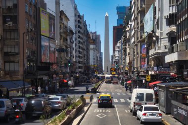 buenos aires, Argentina - 04 November 2022: many cars are driving on an urban inner city avenue with buildings around and obelisk