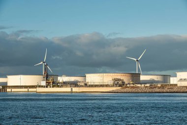 Rotterdam, Hollanda - 22 Kasım 2021: Yeşil ve fosil enerji, rüzgar türbinleri ve fosil yakıtların bir kombinasyonu