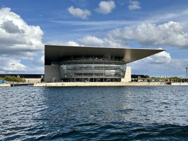Kopenhag, Danimarka - 25 Temmuz 2023: Danimarka 'nın ünlü kraliyet opera binası limandaki modern mimari bir binada yer almaktadır.