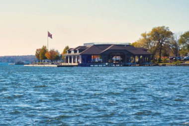 Gananoque, Kanada - 22 Ekim 2022: Tekneler, Kanada bayrağı direğin üzerinde bulunan 1000 adanın yakınındaki marinada bulunan büyük bir kayıkhaneye demirlediler.