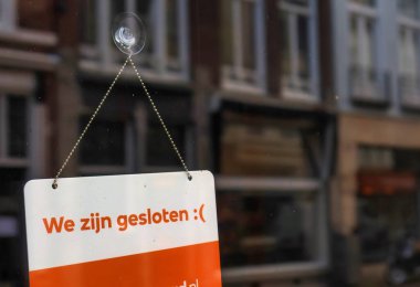 Lahey, Hollanda - 03 Ocak 2022: Hollandalı dilinde kapalı olduğumuza dair bir işaret bir dükkan veya restoranın giriş kapısına yapıştırılmıştır.