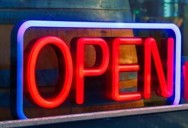 Den Haag, Hollanda - 10 Ocak 2022: Pencerenin önündeki bir dükkanın girişinin yanına neon mavisi açık tabela yerleştirildi