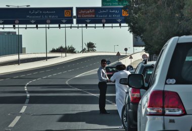 Doha, Katar - 27 Ocak 2010: Terk edilmiş otoyolun ortasında iki araba sürücüsü durdu ve sohbet ettiler
