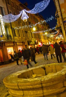 Annecy, Fransa - 18 Aralık 2010: Karlı kış mevsiminde, Orta Çağ Annecy 'de ana alışveriş caddesinde birçok kişi Noel süslemeleri ile birlikte