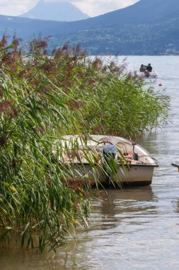 Sevrier, Fransa - 20 Ağustos 2008: Ek bina gölünde yüzen tekne, sazlıkta yatıyor