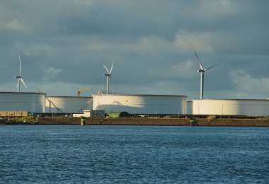 Rotterdam, Hollanda - 11 Kasım 2021: Yeşil ve fosil enerjinin, rüzgar türbinlerinin ve fosil yakıtların birleşimi